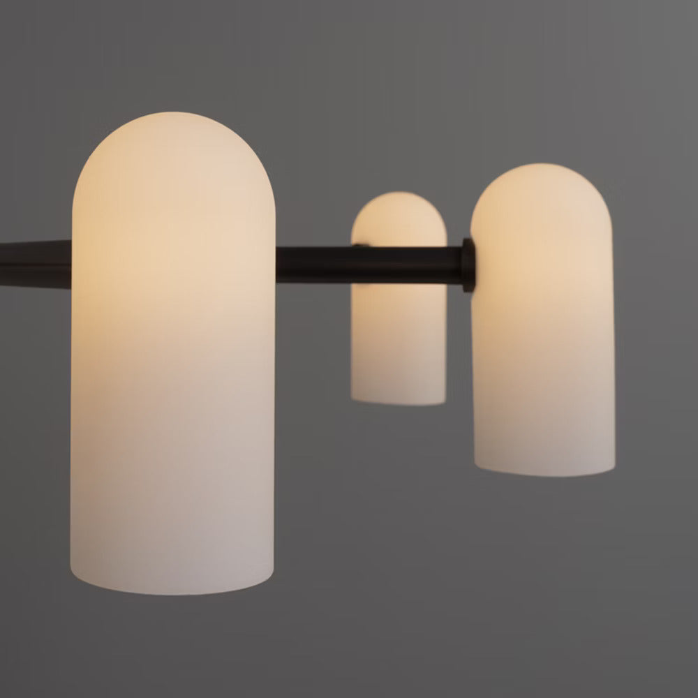 Close-up of a black gunmetal chandelier with lit frosted glass shades.