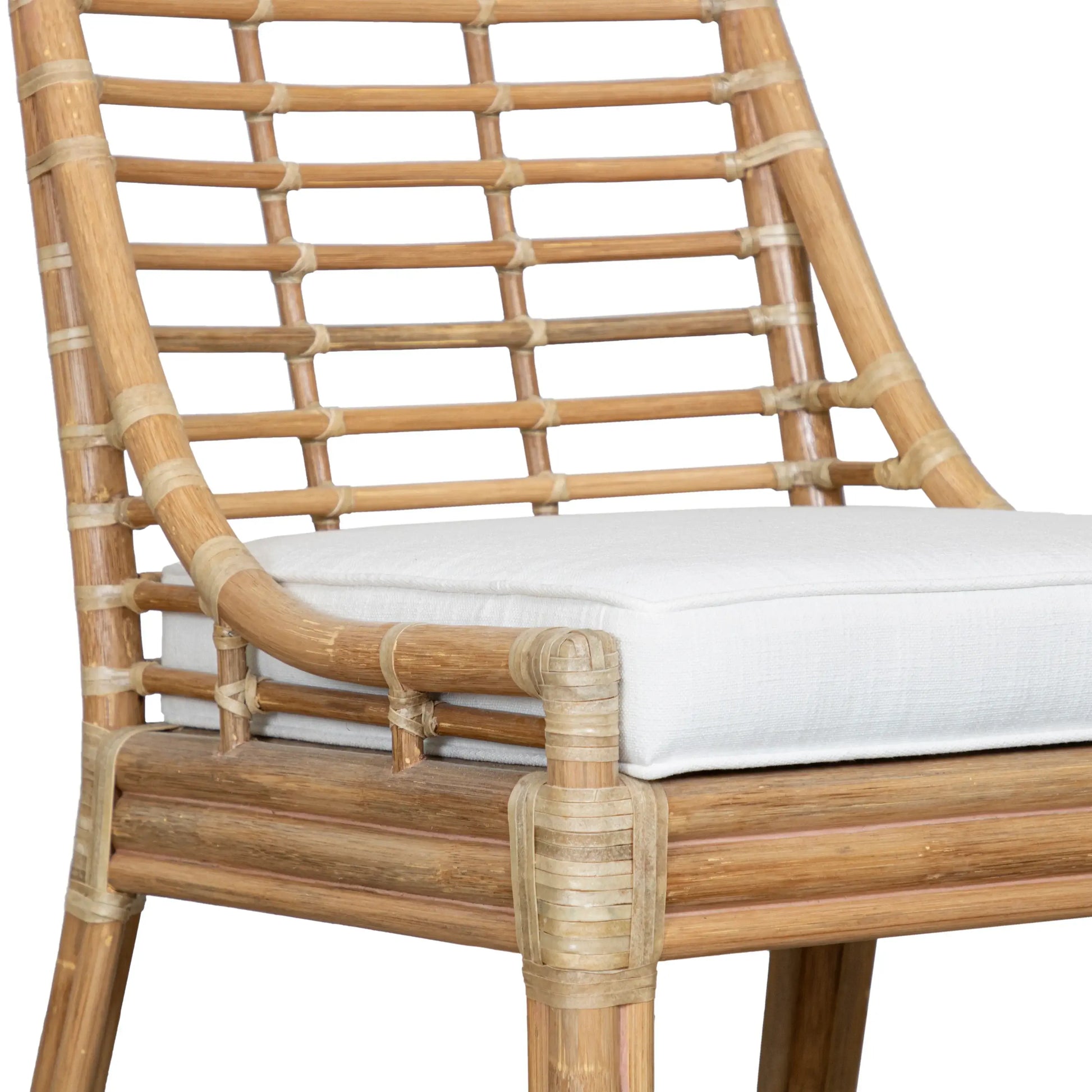 Close-up view of the Luna Dining Chair by David Francis showcasing its natural rattan frame and white upholstered seat cushion.