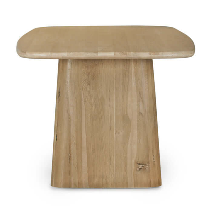 Side view of the Laurel Dining Table Natural by Union Home, highlighting the sculpted base and rounded edges.