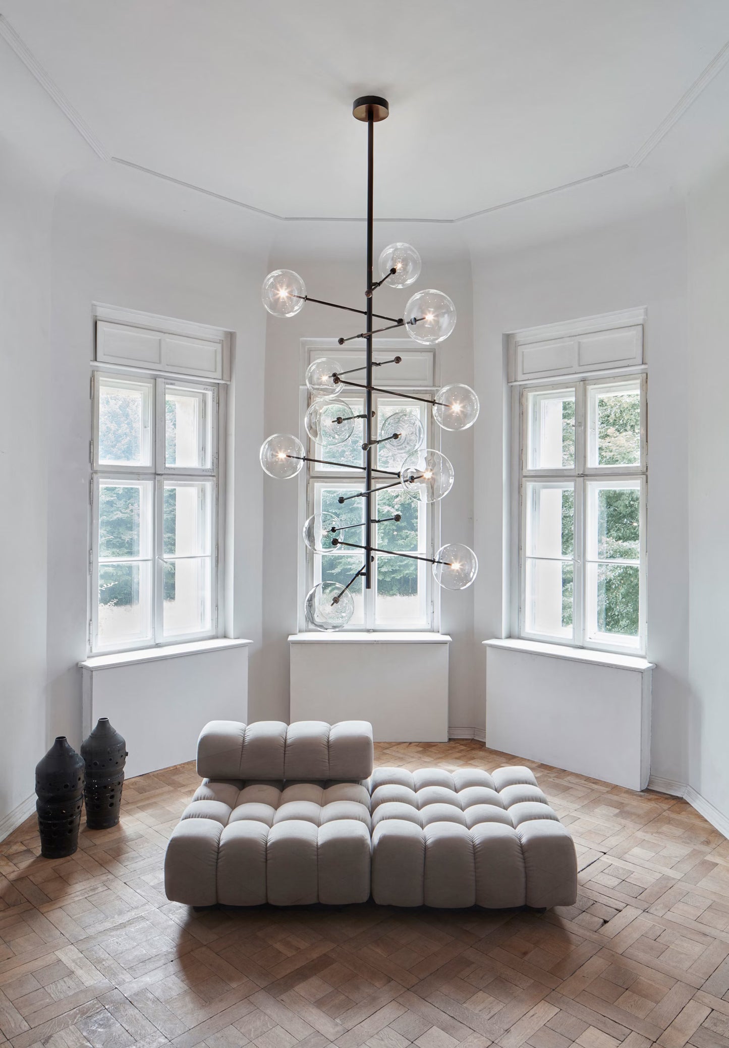 Grand chandelier in a high-ceiling interior with natural light.