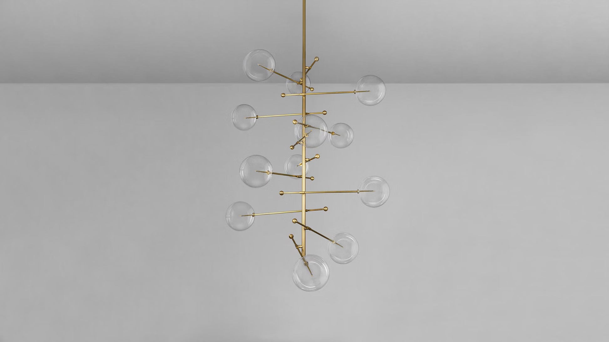 Transparent glass globe chandelier with brass rod frame.