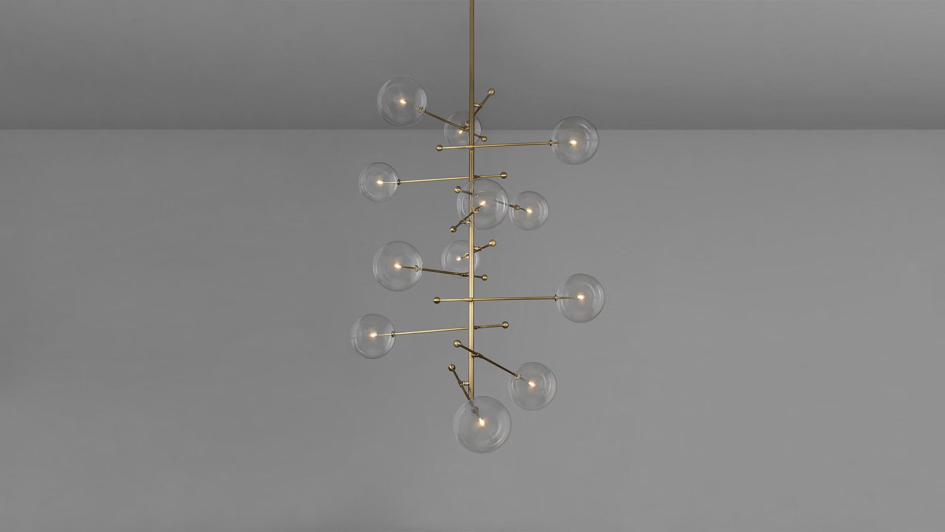 Brass rod chandelier with handblown glass globes turned on.