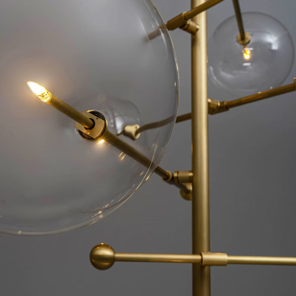 Close-up of illuminated glass globe with brass rod detailing.