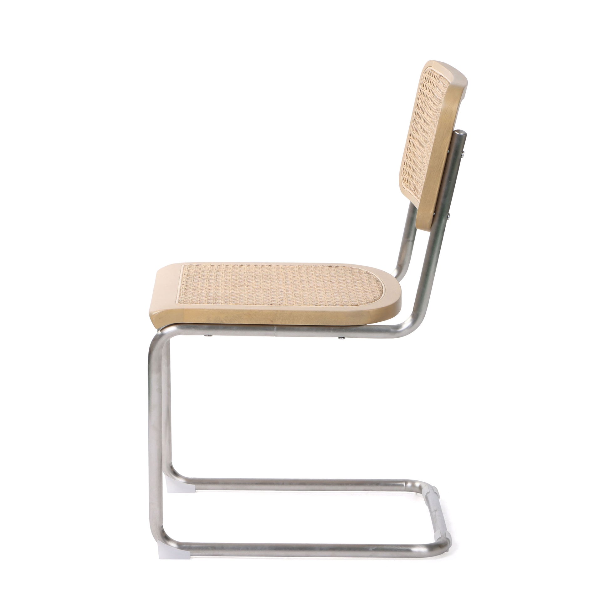Profile view of a beige cane dining chair with tubular steel frame.