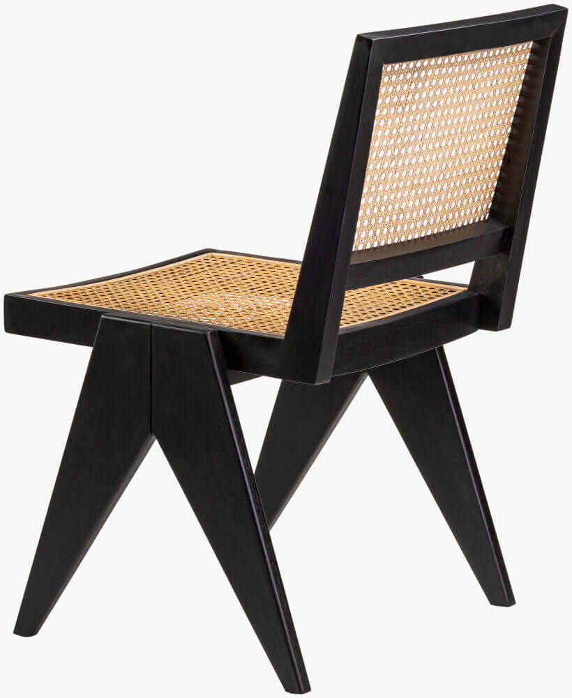 A close-up of the black rattan dining chair, showcasing its woven back and seat with angular black wooden legs, highlighting the chair's modern design.
