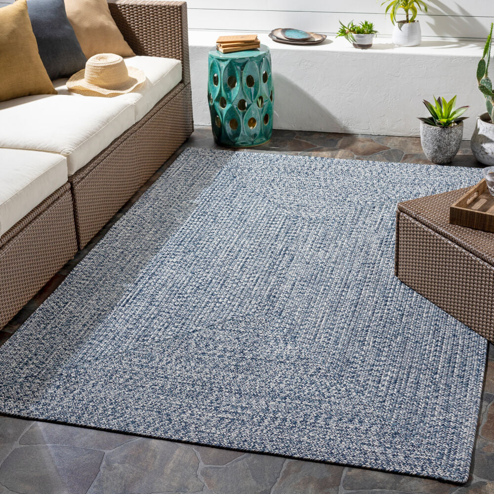 Blue woven polypropylene rug styled in a bright living area with natural light.