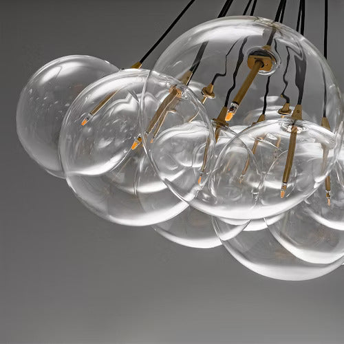 Close-up of handblown borosilicate glass globes tethered by brass accents.