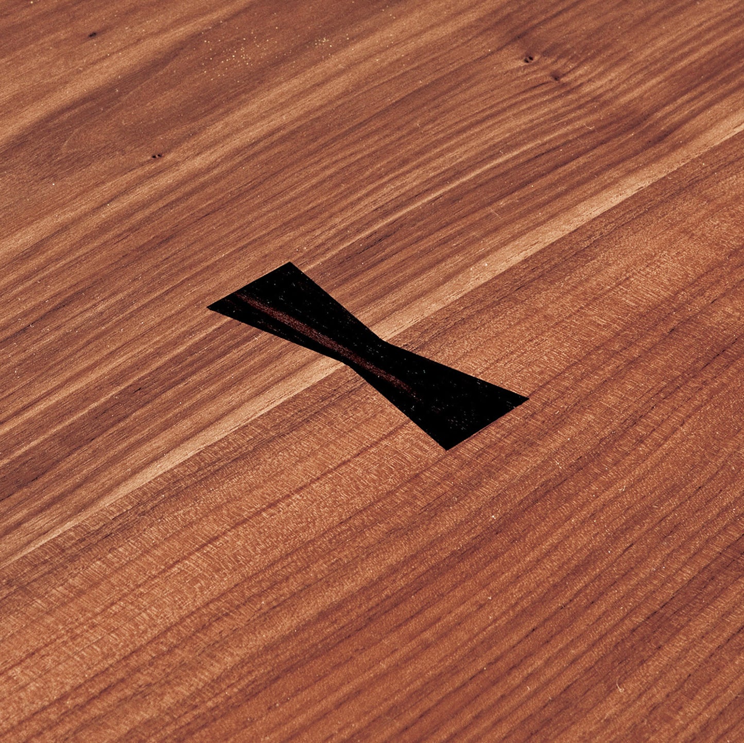 Detailed view of the Hakama Dining Table’s handcrafted butterfly joinery.