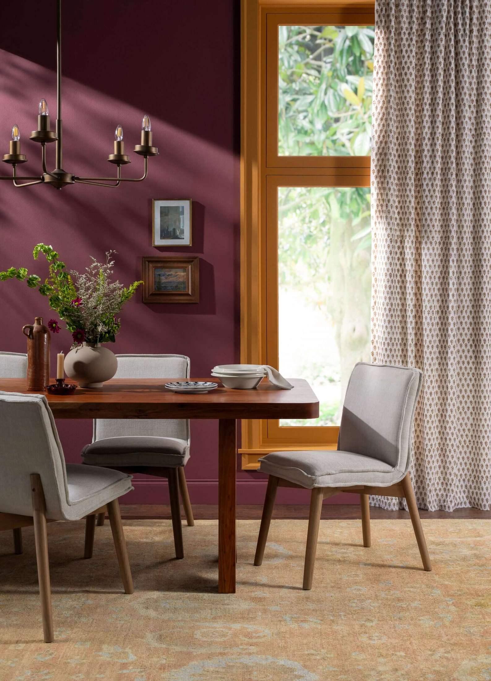 The Joiner Dining Table in a cozy dining room setup with warm lighting and modern decor.