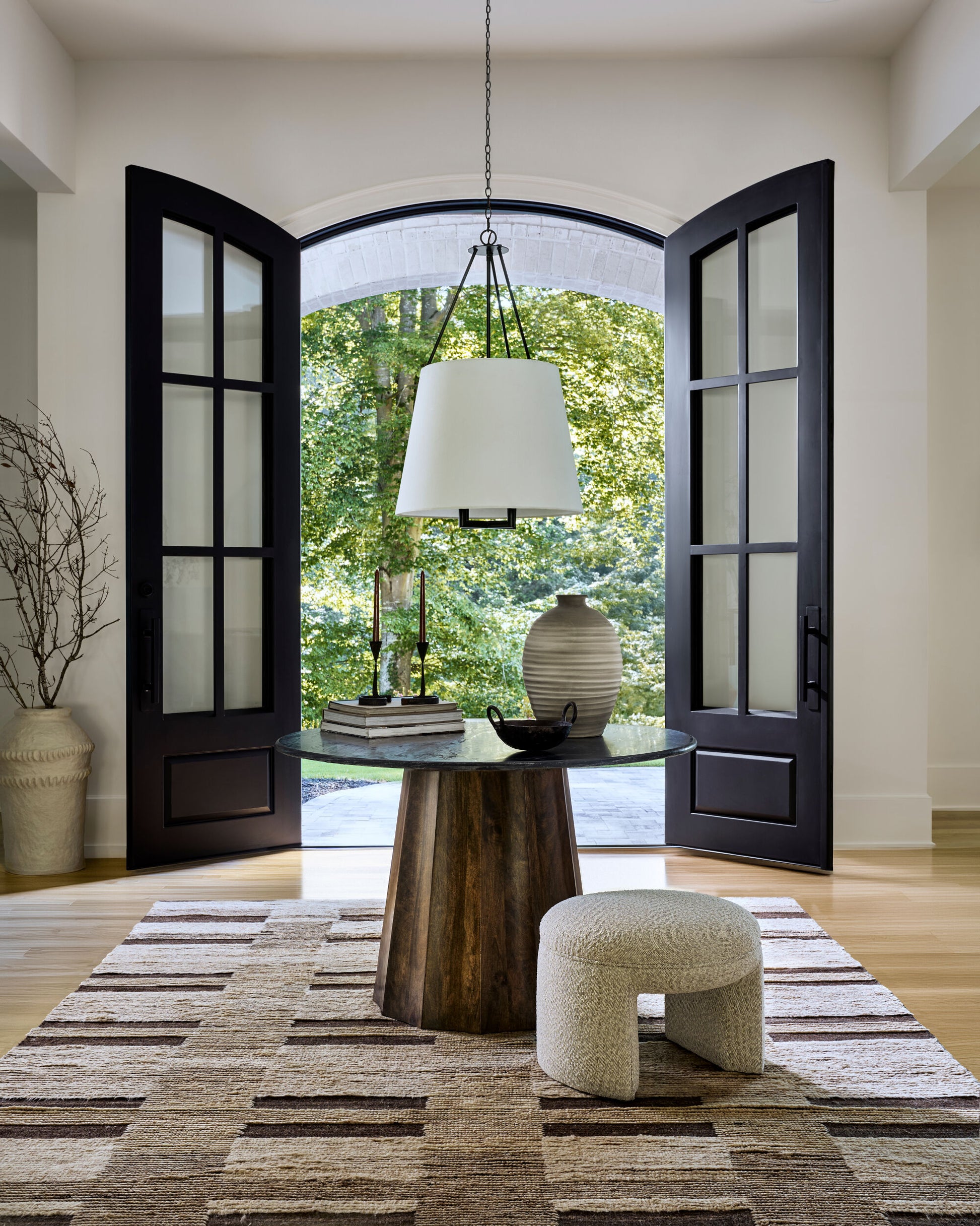 Linus Dining Table with a black marble top and mango wood base in a bright, elegant dining area.