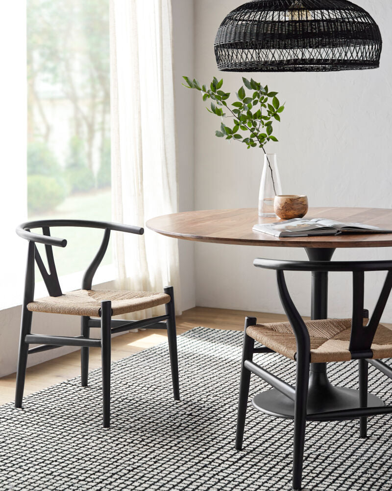 Linxia Black Mid-century teak wood dining chairs with seagrass seats in a dining room setup.