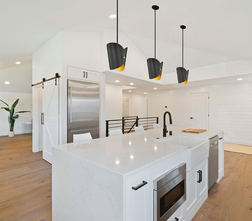 Trio of modern one-light pendants matte black over white island.