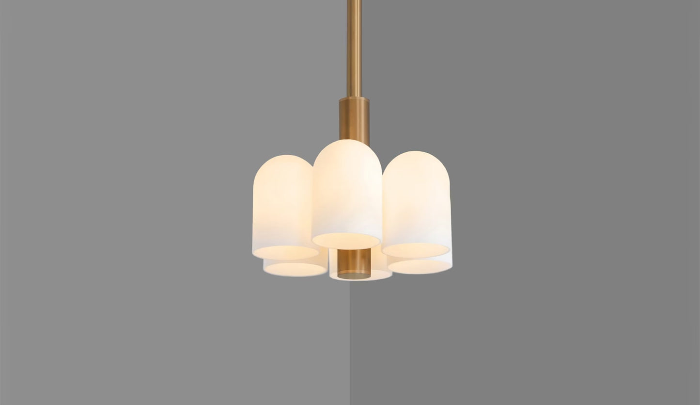 Modern 6-light pendant in brass with warm light through frosted glass shades.