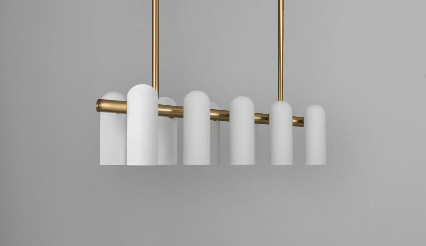 Modern brass linear chandelier featuring frosted glass shades and elegant warm metallic accents.