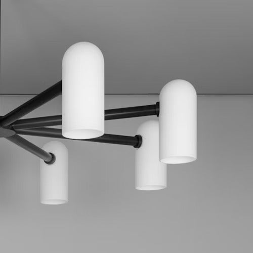 Closeup of Black chandelier with large cylindrical frosted glass shades.
