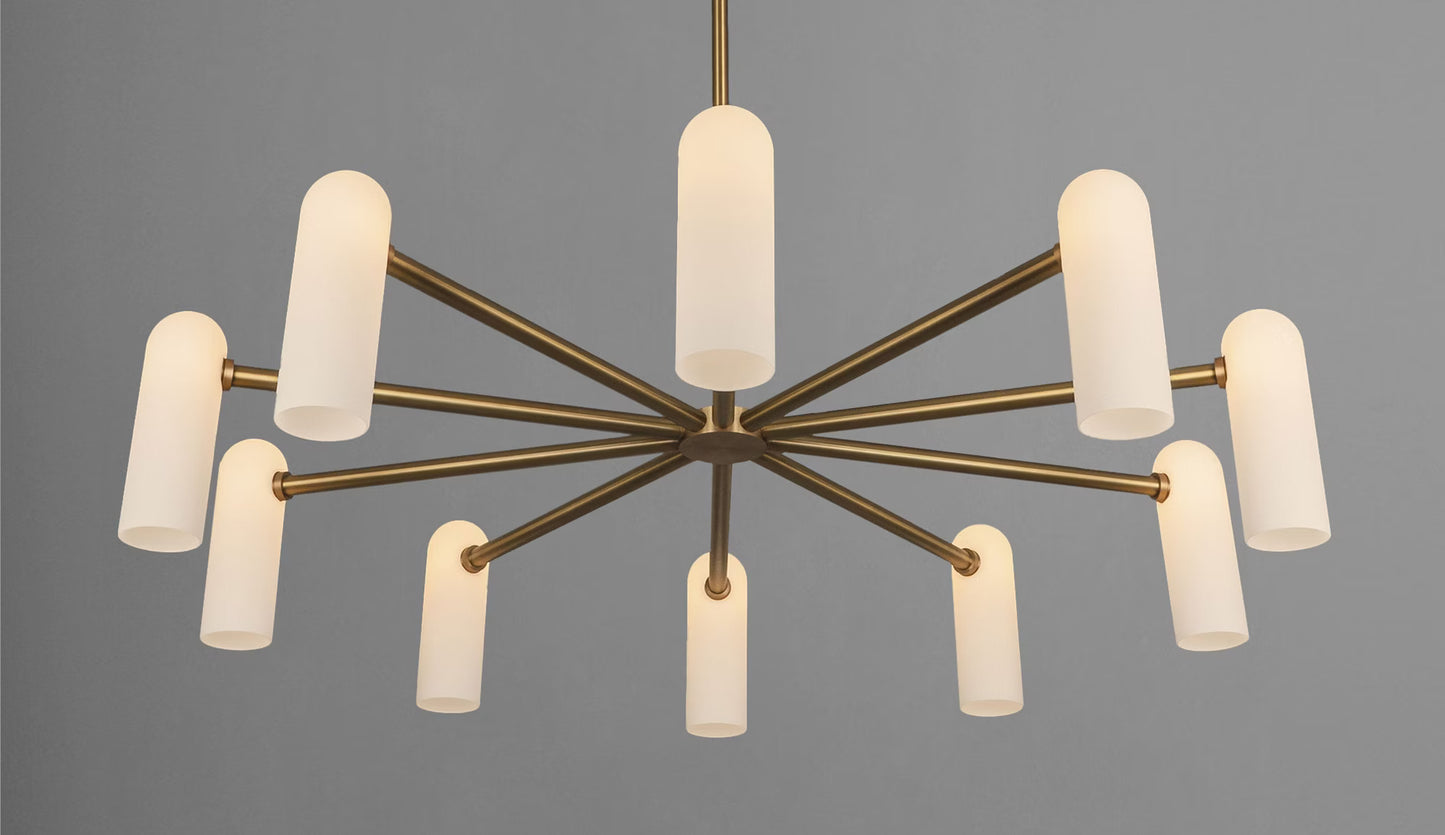 Close-up of a brass ceiling chandelier with warm glowing glass shades and soft diffused lighting.