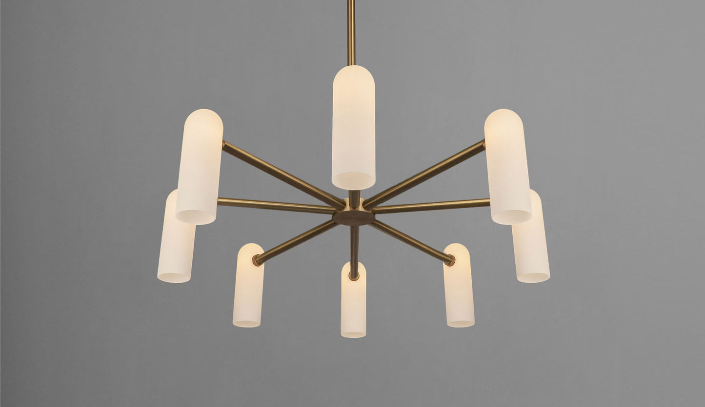 Elegant brass chandelier with eight softly illuminated opal glass shades, radiating warm light.