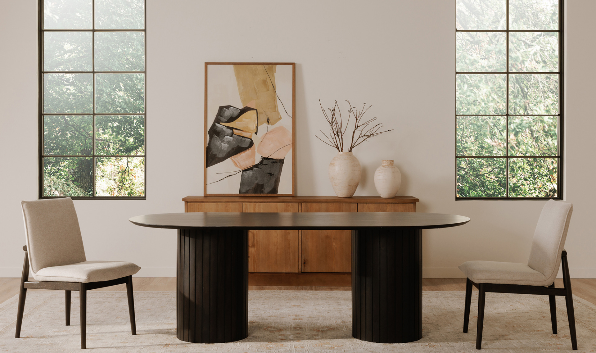 Povera Black Dining Table with ribbed columns paired with beige chairs in a contemporary dining room.
