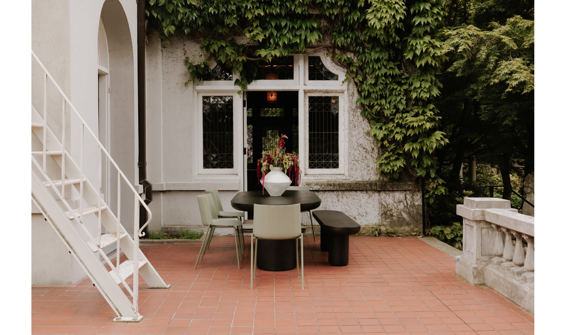 Rocca black concrete dining bench in modern outdoor dining setup