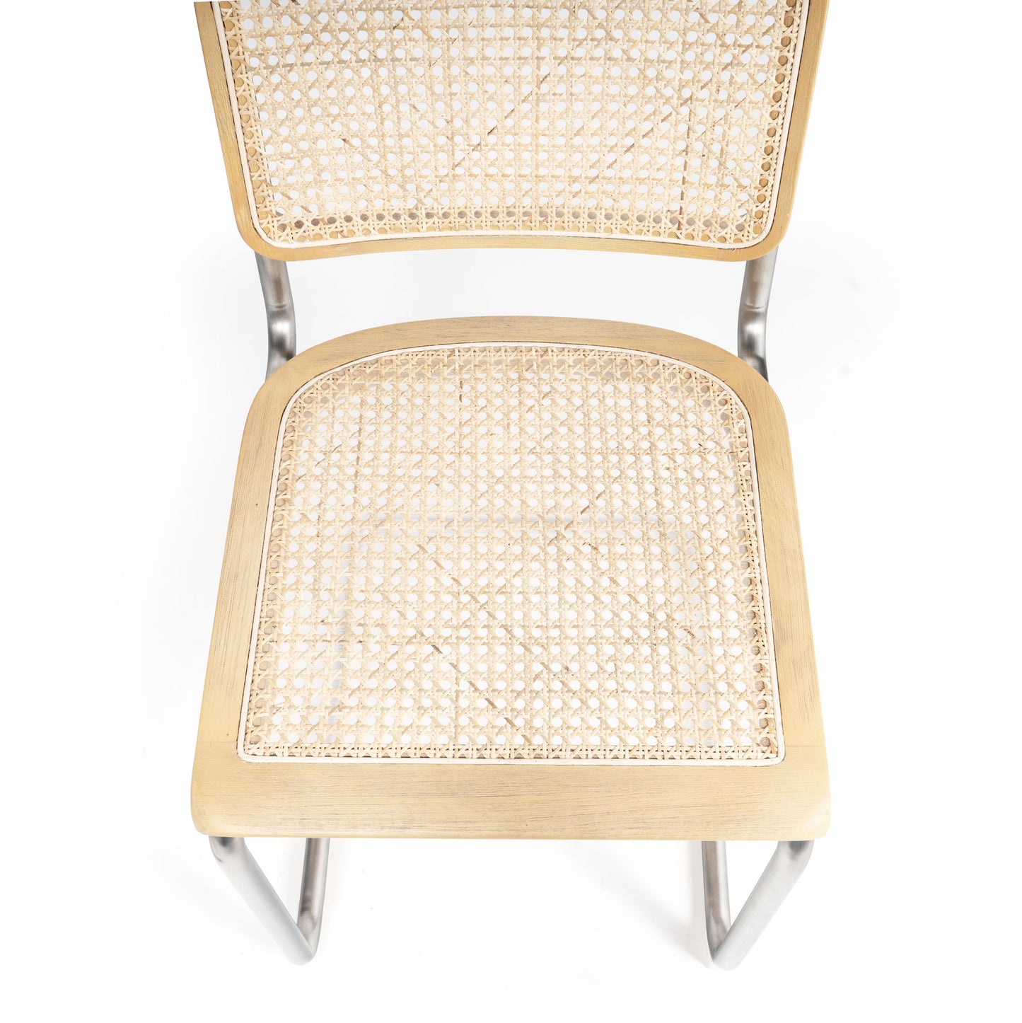 Top-down view of the woven cane seat and backrest on a brown dining chair with rounded corners.