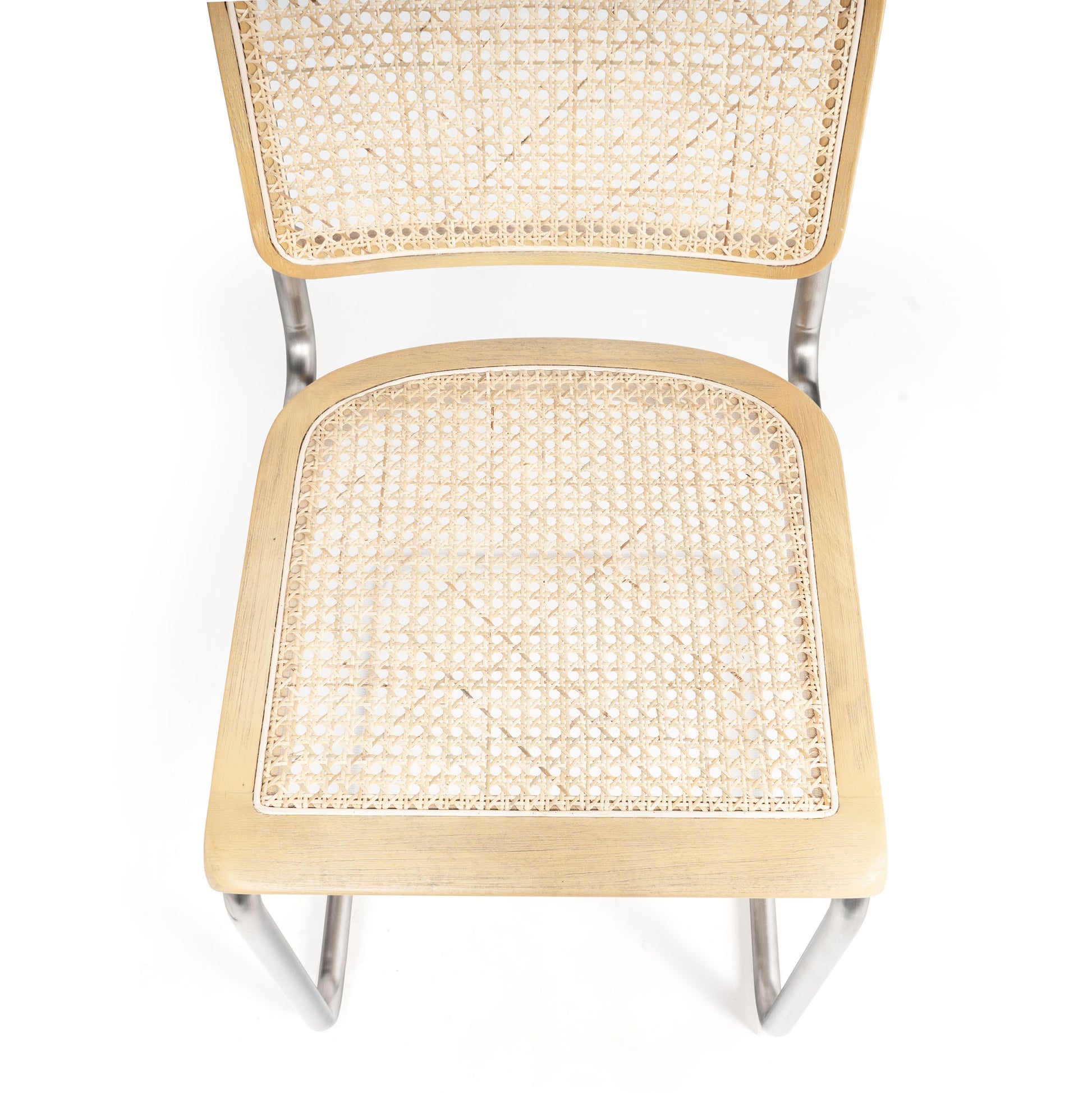 Top-down view of the woven cane seat and backrest on a brown dining chair with rounded corners.