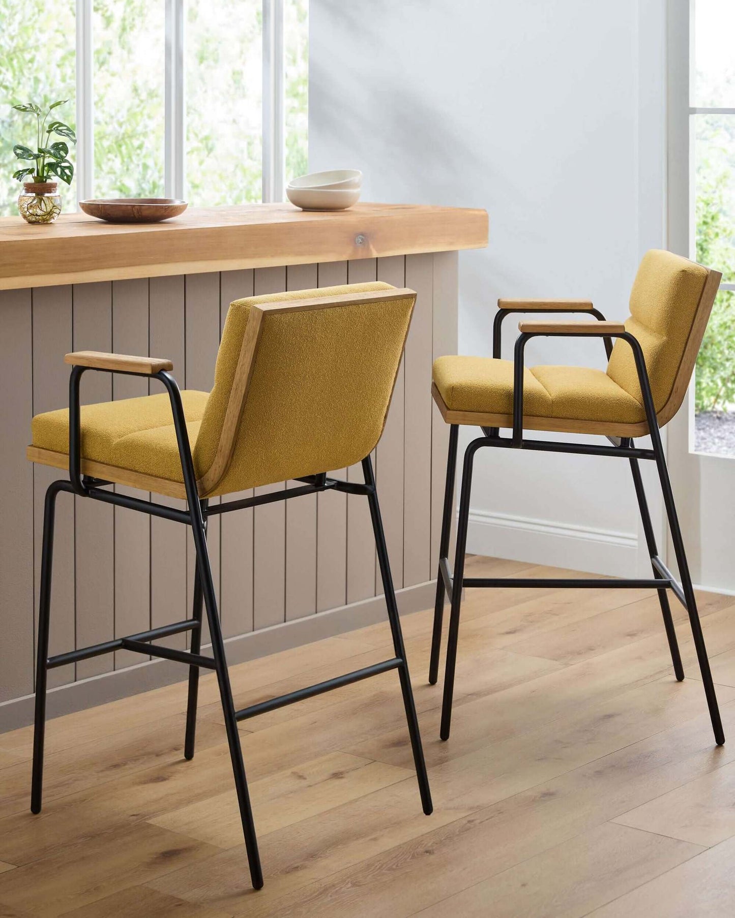 Stylish setting featuring two Thomas Bar Stools by Surya at a wooden counter, emphasizing the bold yellow seats and industrial design.