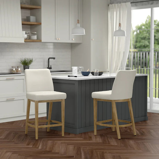 Modern kitchen with gray island, white upholstered bar stools, pendant lights, wood shelving, white subway tile backsplash, and herringbone wood floor.