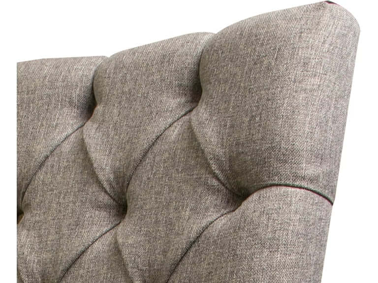 Close-up of tufted backrest in gray fabric on an elegant mango wood dining chair.