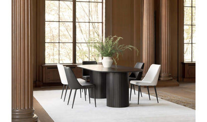 Povera Black Dining Table set in a stylish dining room with large windows.