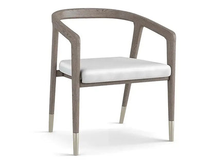 Angled view of the Hampstead Dining Arm Chair, showcasing its modern design and brushed pewter accents.