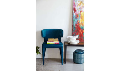 Jennaya Teal Dining Chair styled with books and decor in a modern room.