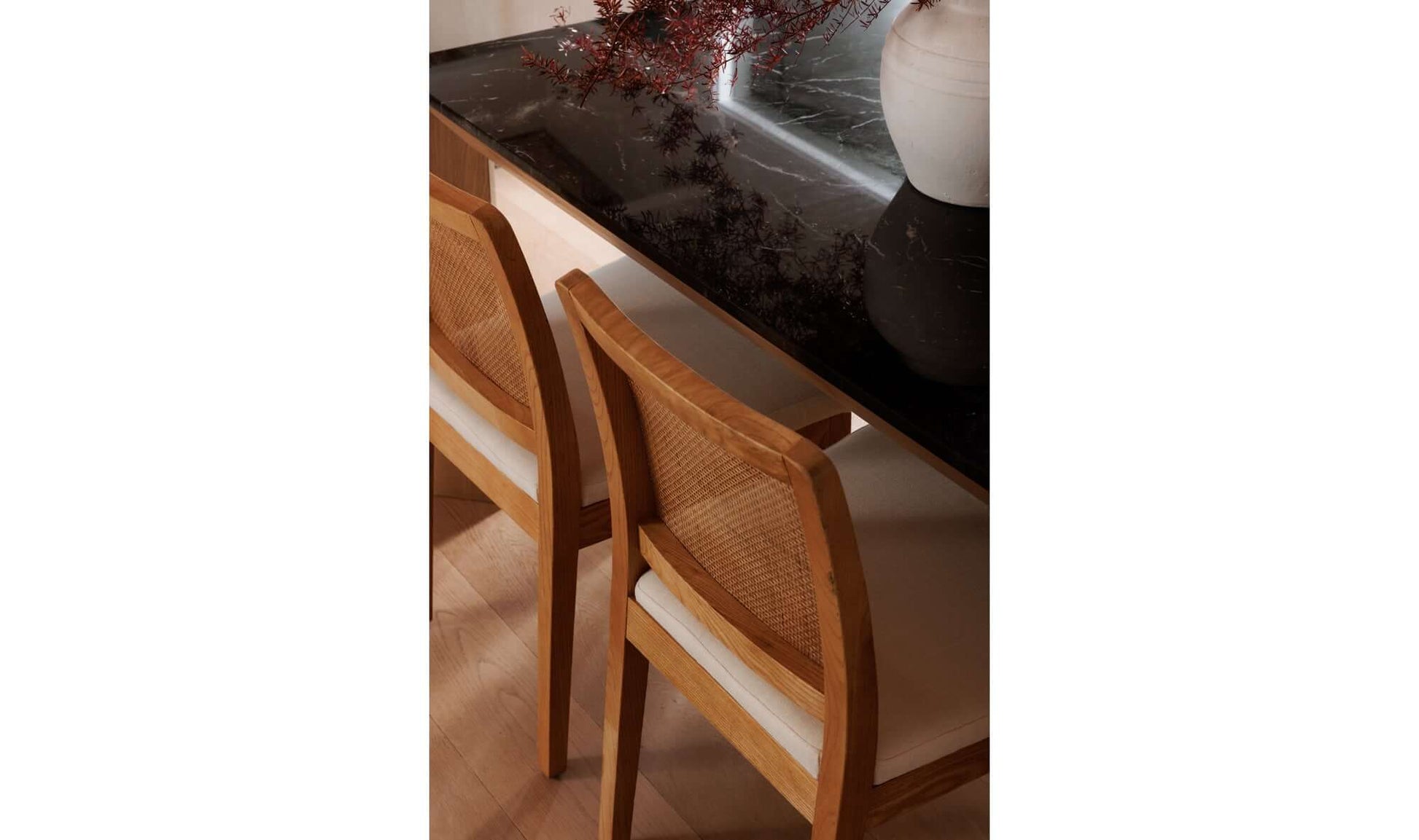 Top view of Orville Natural Dining Chairs around a black marble dining table.