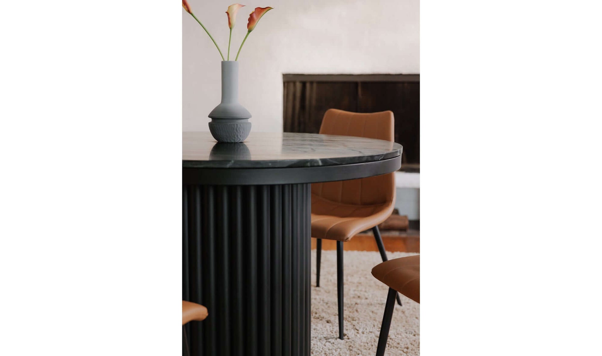 Close-up of the Tower Black Marble Dining Table, showing its marble top and pillar base.