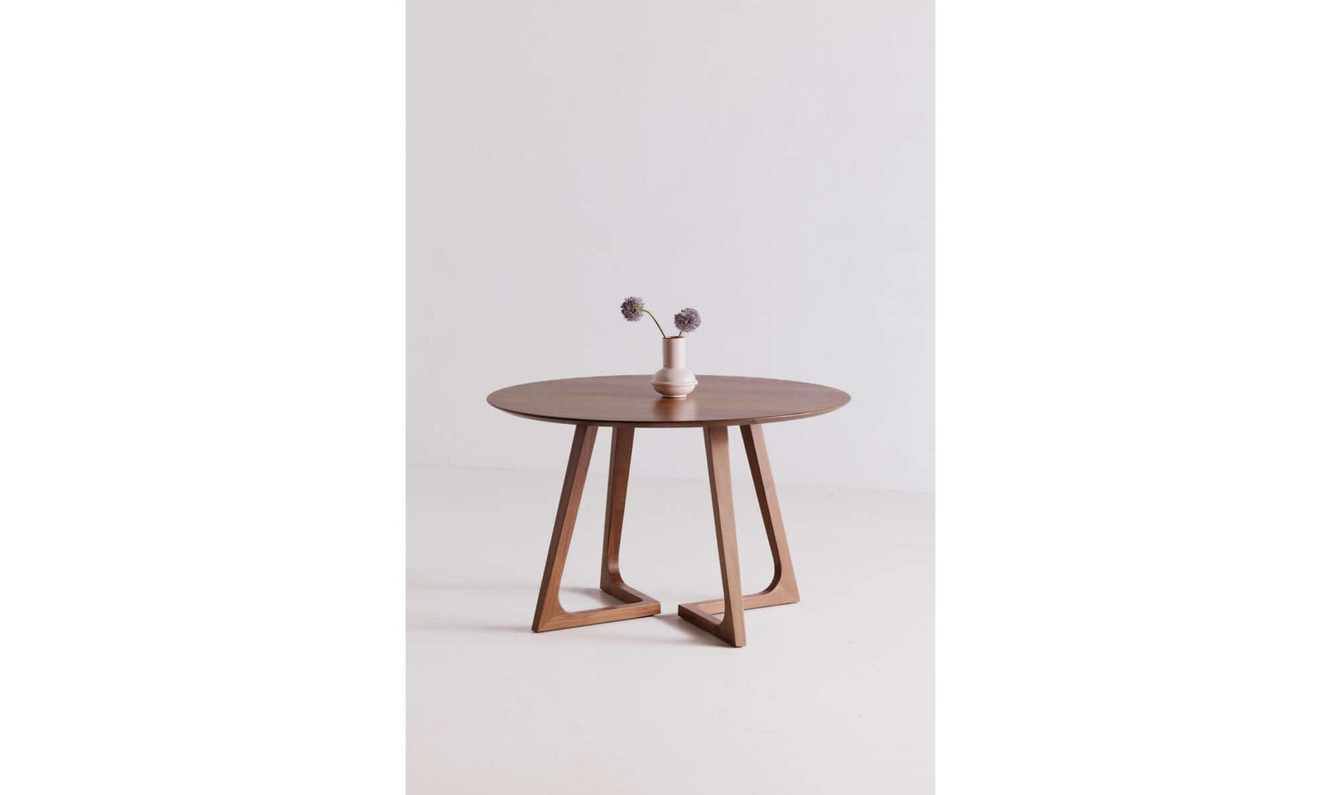 Godenza Round Brown Dining Table with simple centerpiece in a minimalist setting