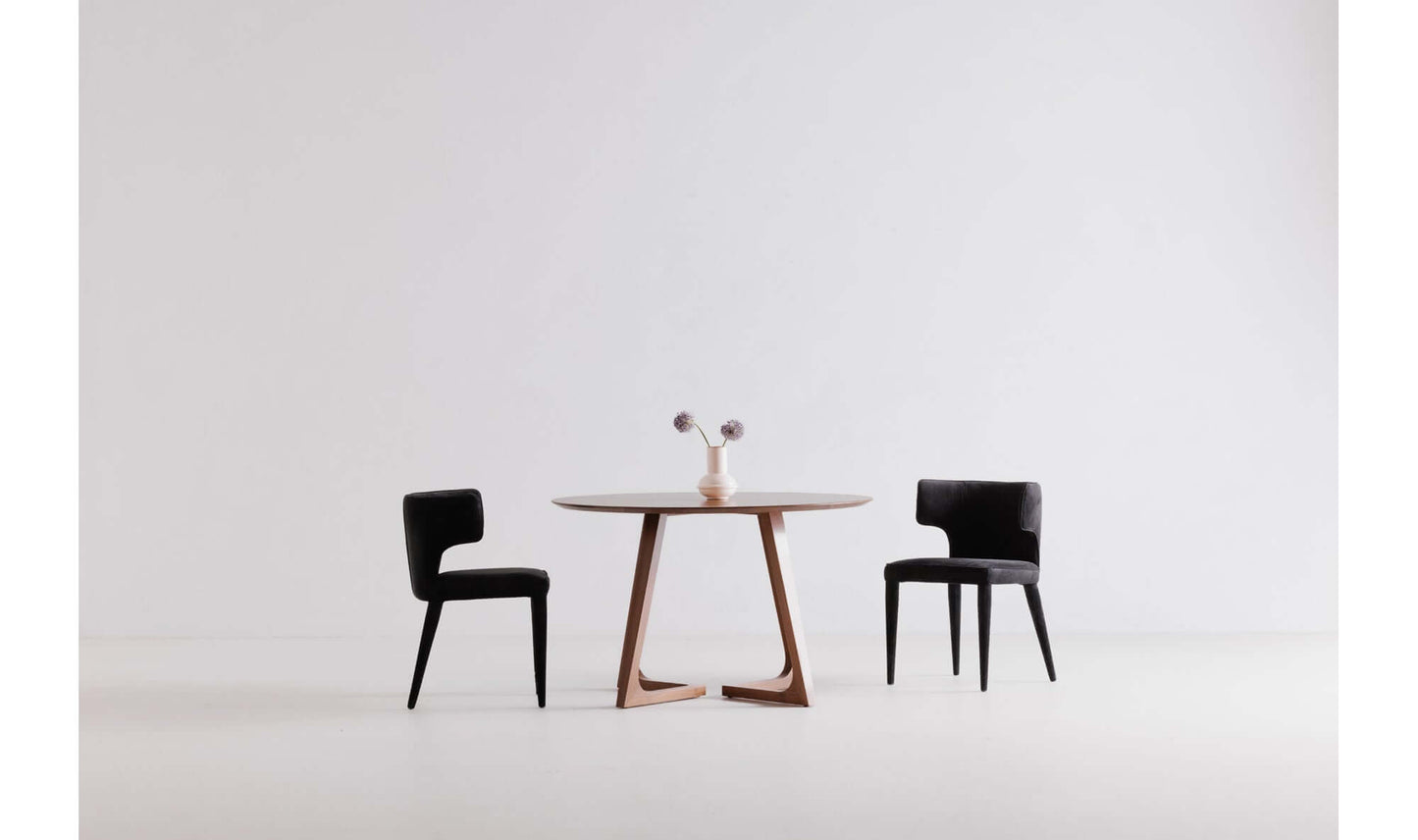 Jennaya Black Dining Chair displayed with a modern dining table in a minimalist setting.