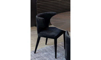 Close-up of Jennaya Black Dining Chair with plush polyester upholstery by a modern dining table.