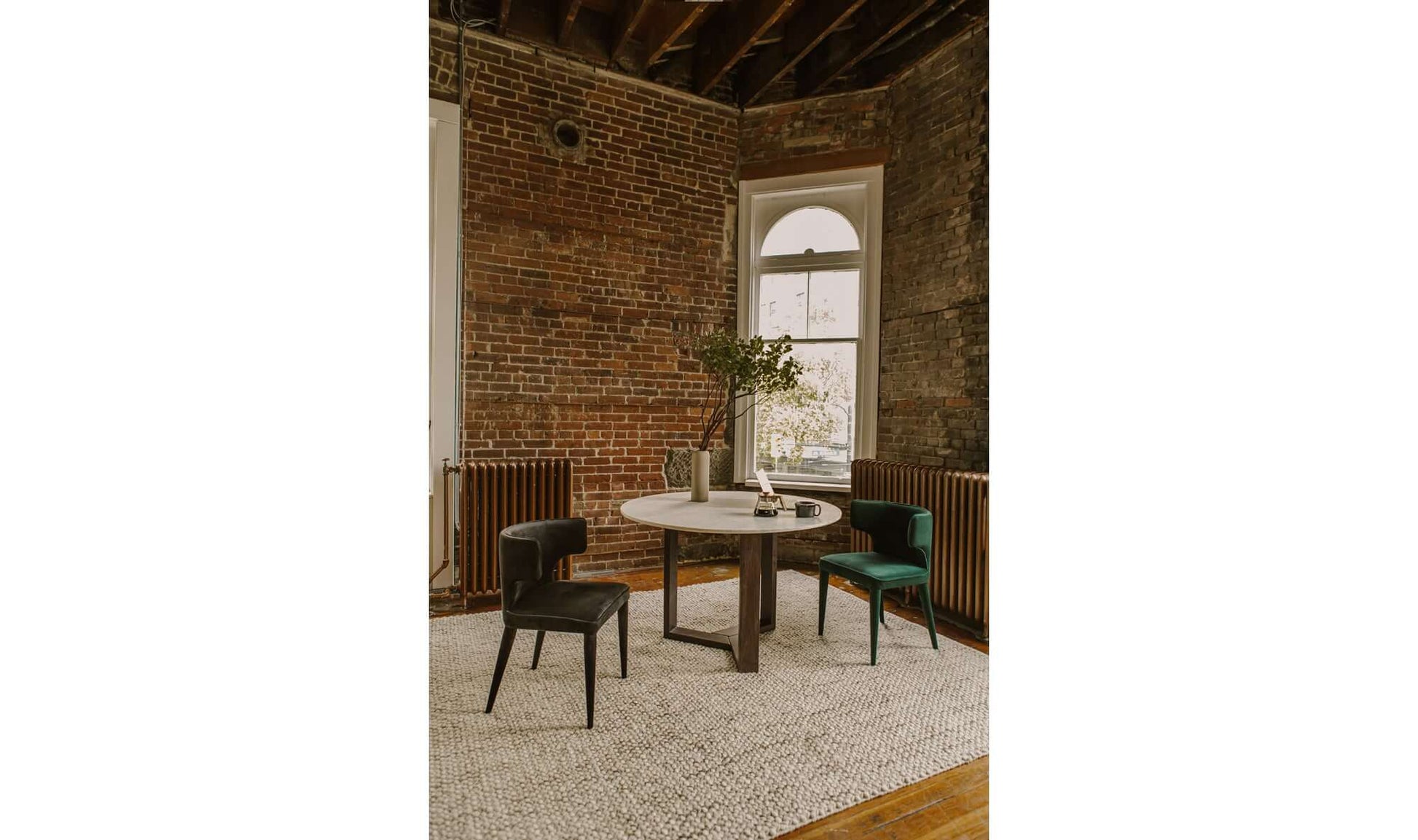 Elegant dining room featuring Jennaya Black Dining Chairs with brick wall background.