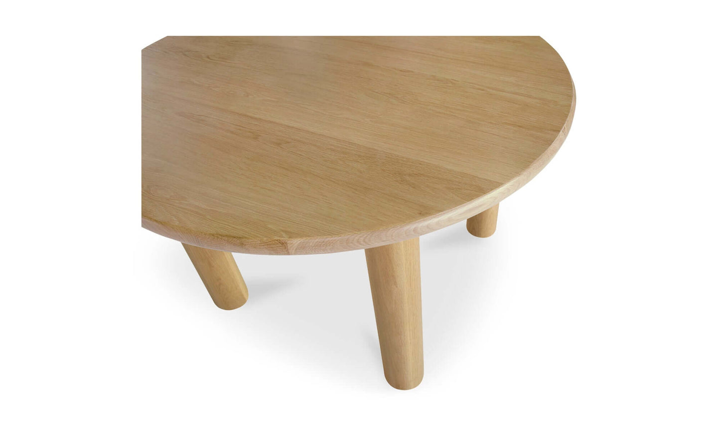 Detailed view of the Milo Round Oak Dining Table's sleek column legs and oak tabletop.