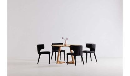 Godenza Round Oak Dining Table with four black chairs, showcasing seating capacity.