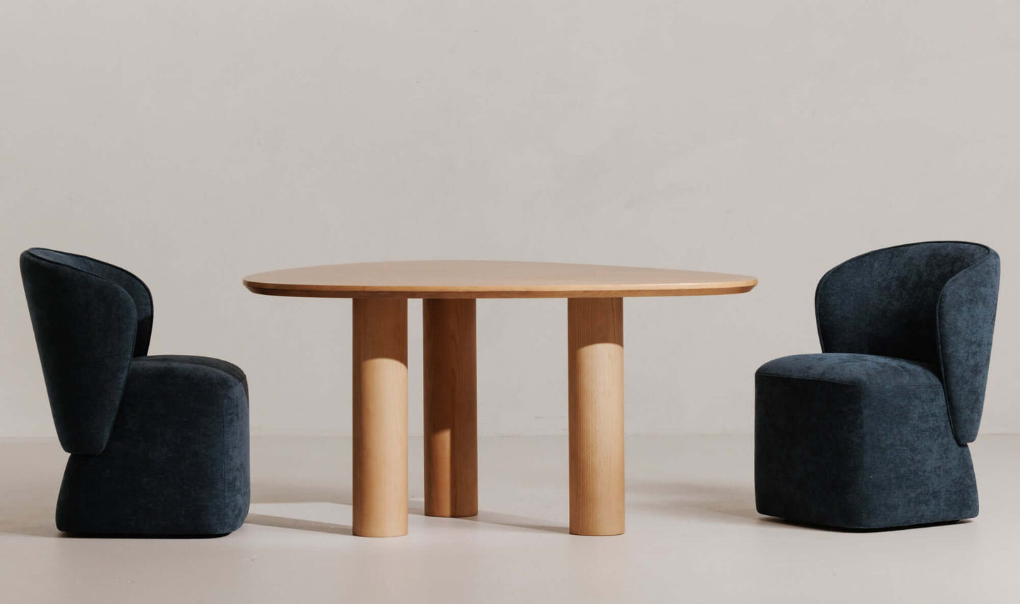 Finley dining table in a modern dining room setup with two blue chairs.