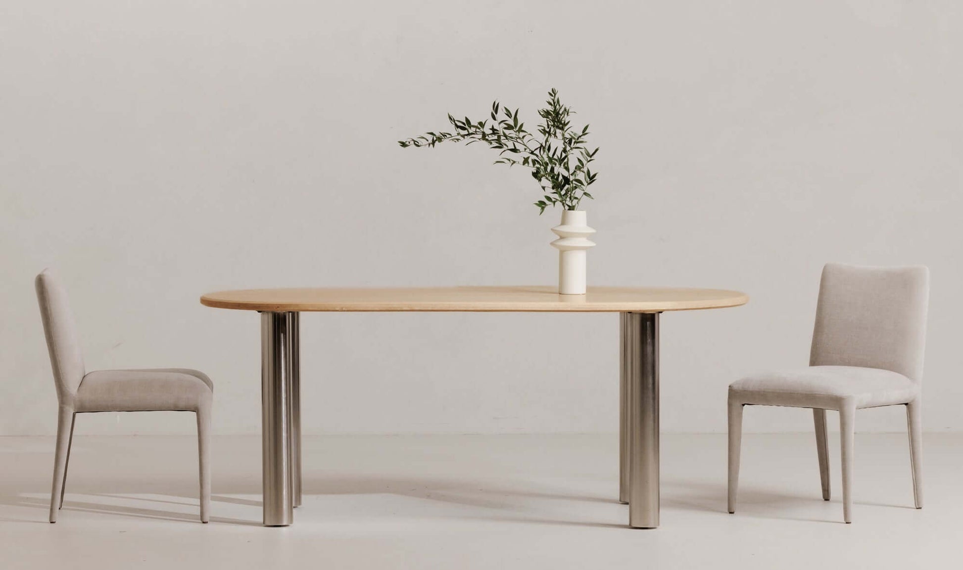 Fia Dining Table Travertine styled with minimalist décor in a modern dining space.