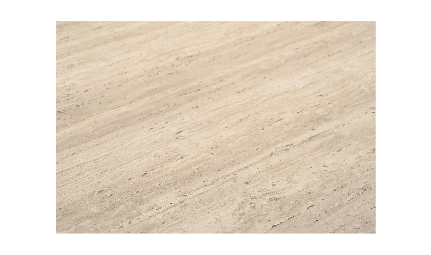 Detailed texture of the beige Italian travertine top of the Fia Dining Table.