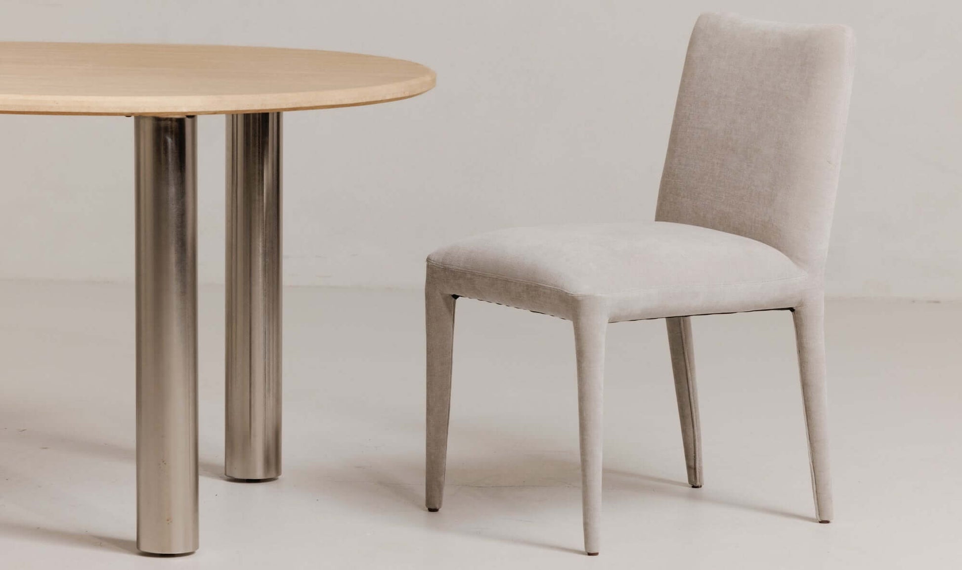 Calla Light Grey Dining Chair next to a dining table with metal legs from Moe's Home Collection.