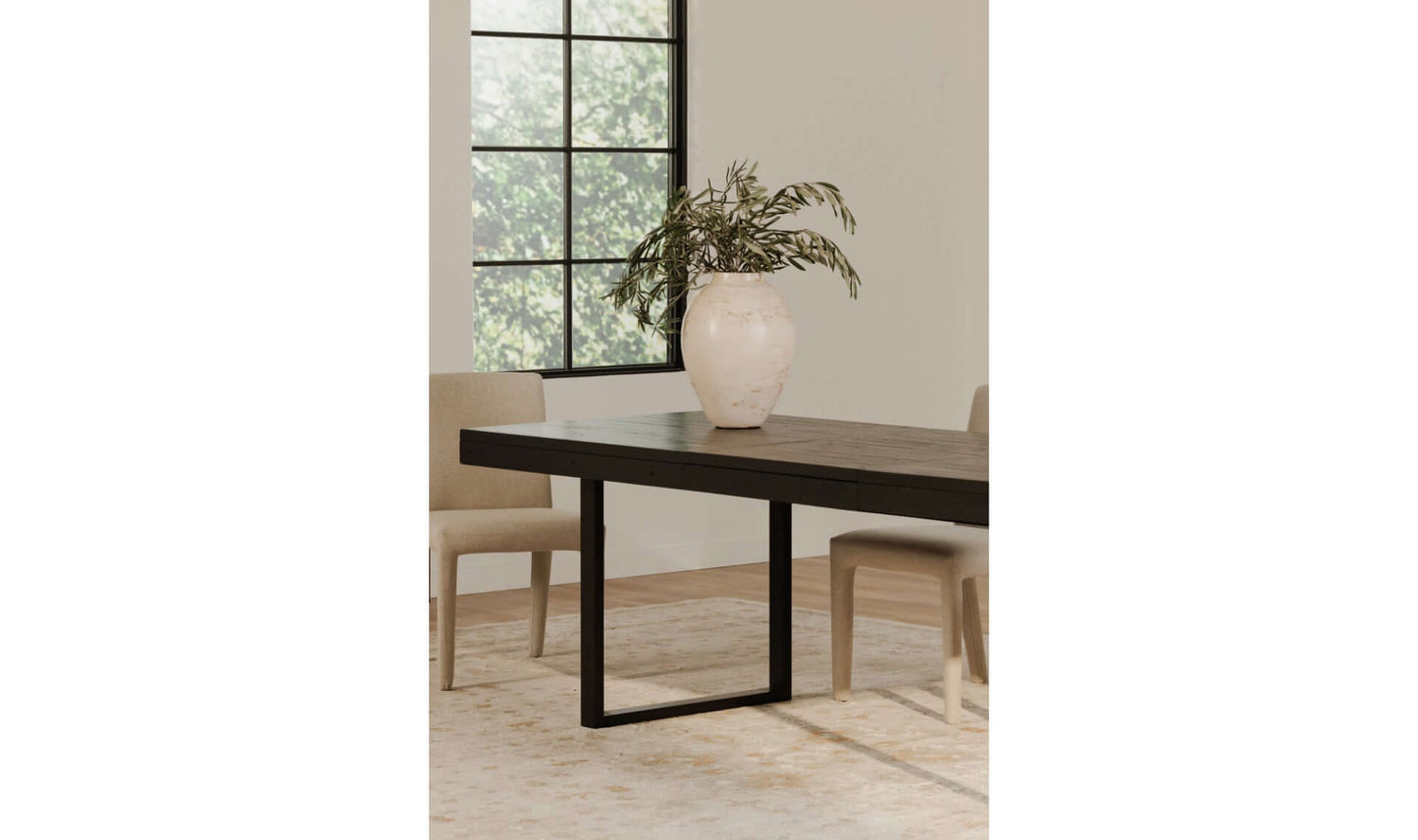 The Ben Extension Dining Table set in a contemporary dining room, paired with neutral chairs and decor, emphasizing its versatile and modern design.