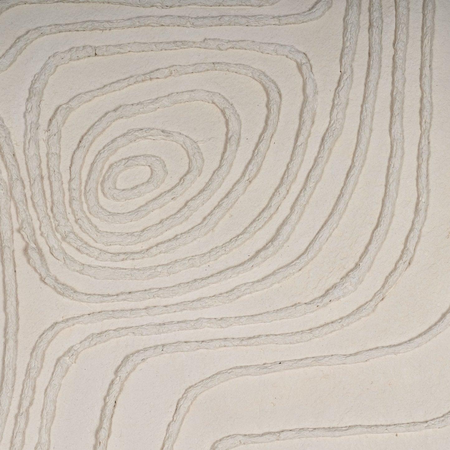 Close-up of textured concentric lines on a neutral-tone canvas.