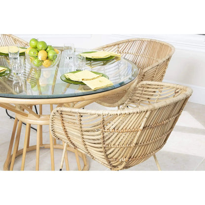 David Francis Bali modern rattan dining arm chair around a glass dining table, showcasing its natural rattan and black metal legs