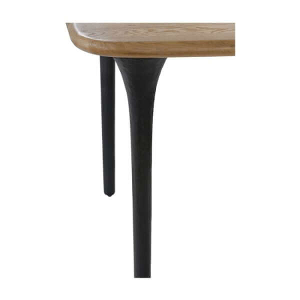 Detail of the Union Home Etro Dining Table's sandblasted, cast metal leg, showing industrial-style finish.