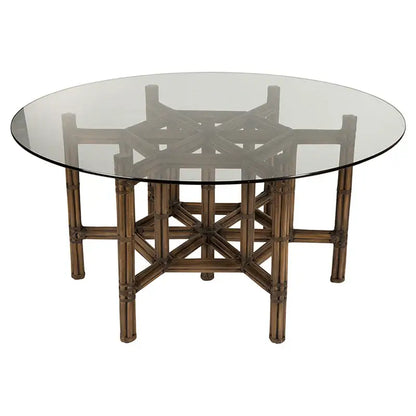 Dark rattan dining table base paired with a glass top for a sleek and contemporary look.