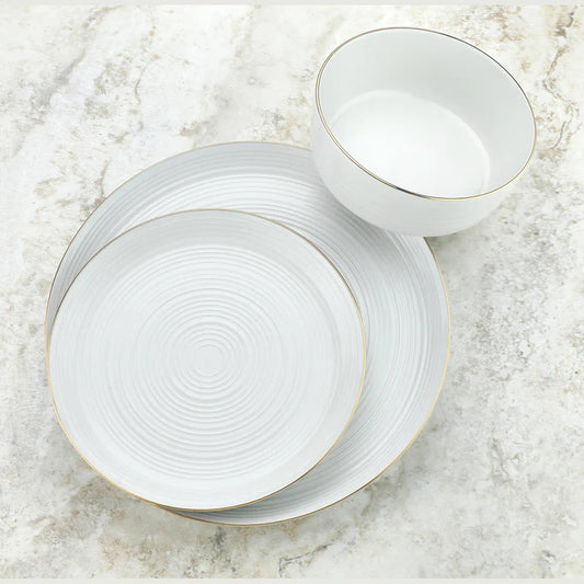 Godinger porcelain 12 piece dinnerware set with ripple texture and gold rims, featuring bowls and plates on a marble surface.