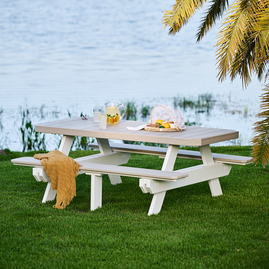 Scenic view of a 6’ rectangular picnic table in weatherwood color by a lake, set up for outdoor dining.